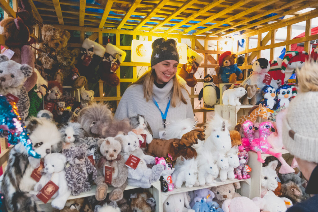 A happy exhibitor selling children's toys and gifts at Fowey Christmas Market